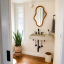 Cream wall-mounted concrete sink handcrafted by Curated Concrete in a minimalist powder room
