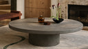 Round concrete coffee table styled in a modern living room, handcrafted by Curated Concrete